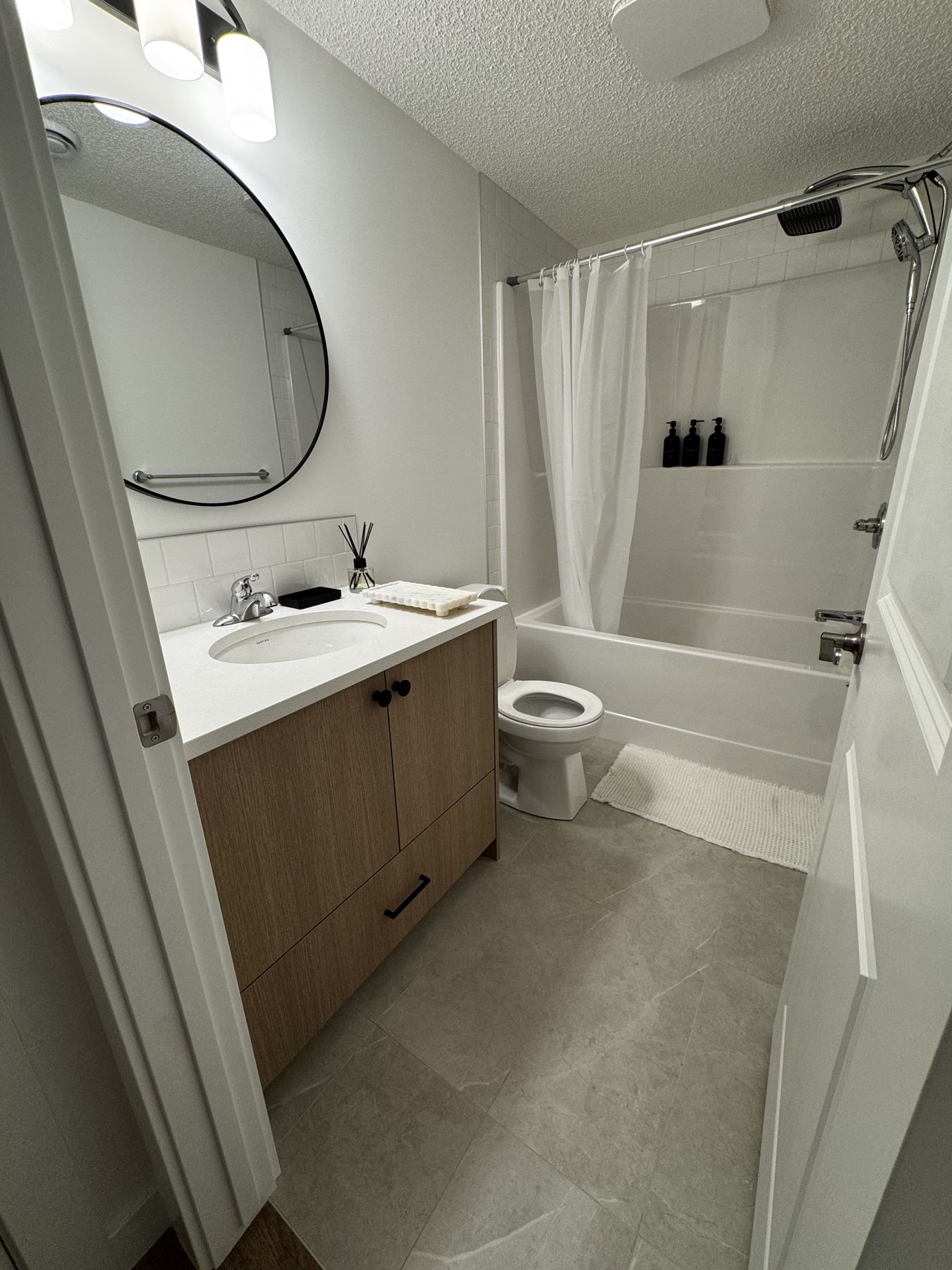 Bathroom with round mirror and tub
